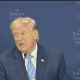 Man speaking at podium with blue backdrop