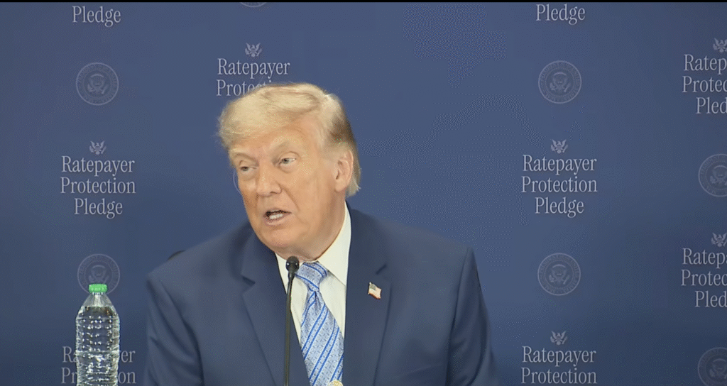 Man speaking at podium with blue backdrop