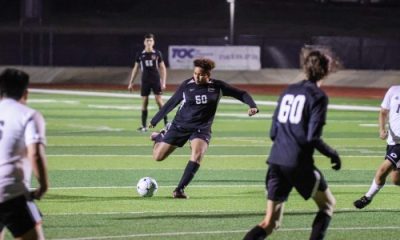Soccer player kicking ball during nighttime match
