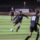 Soccer player kicking ball during nighttime match