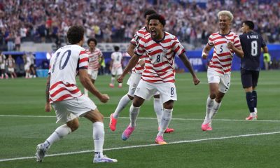 Soccer players celebrating goal in packed stadium