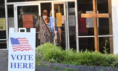 People entering polling place with Vote Here sign