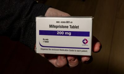 A hand holding a box of mifepristone tablets, labeled 200 mg, emphasizing the medication's i — mifepristone lawsuit paused