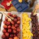 A school cafeteria table filled with fresh fruits like apples, oranges, and grapes, alongsid — SNAP cuts free school lunch