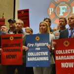 Group of people holding signs advocating for collective bargaining at a labor union event. — labor union membership growth