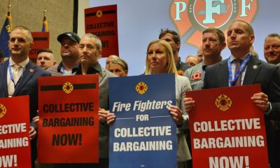 Group of people holding signs advocating for collective bargaining at a labor union event. — labor union membership growth