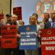 Group of people holding signs advocating for collective bargaining at a labor union event. — labor union membership growth