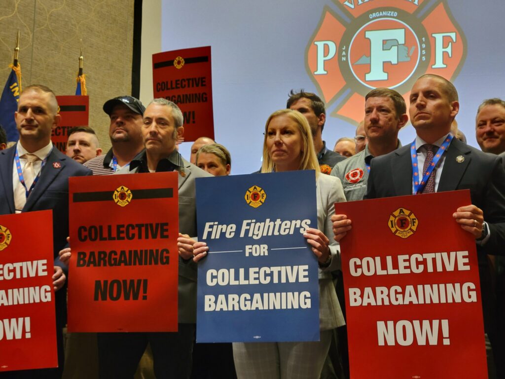 Group of people holding signs advocating for collective bargaining at a labor union event. — labor union membership growth