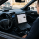 Police officer using laptop inside patrol car — AI in policing Pensacola