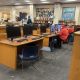 Library interior with computers, students using them, and a welcome sign on the wall, highlighting E-Rate program funding…