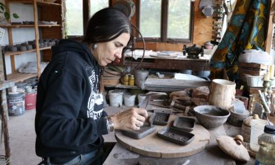 A woman working on pottery in a cozy studio filled with various tools and materials. — alpha-gal syndrome