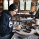 A woman working on pottery in a cozy studio filled with various tools and materials. — alpha-gal syndrome