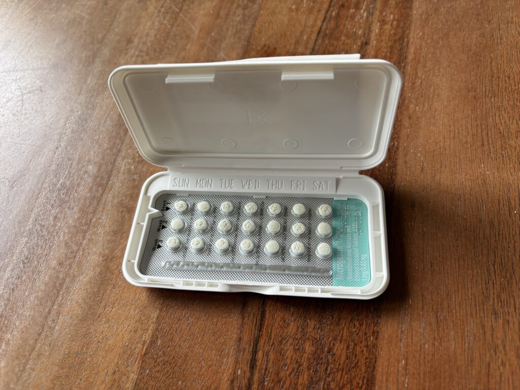 A pack of birth control pills open on a wooden surface, highlighting the days of the week o — birth control misinformation