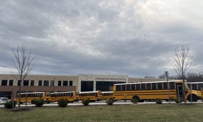 Hammond High School with several yellow school buses parked in front under a cloudy sky, — violent victimization at school