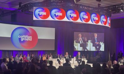 Panel discussion featuring multiple governors on stage at a conference, with a large scre — governor phil scott federalism