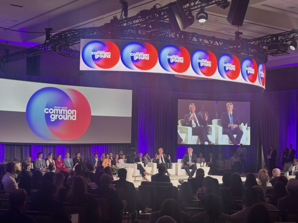 Panel discussion featuring multiple governors on stage at a conference, with a large scre — governor phil scott federalism