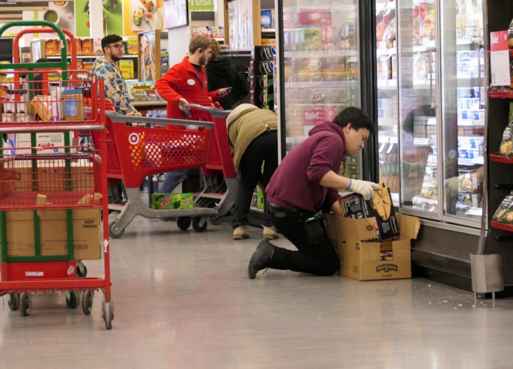Employee stocking frozen food in grocery store aisle — minimum wage increases july
