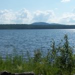 Scenic view of a lake surrounded by greenery and mountains under a cloudy sky, hig — New York drinking water contamination