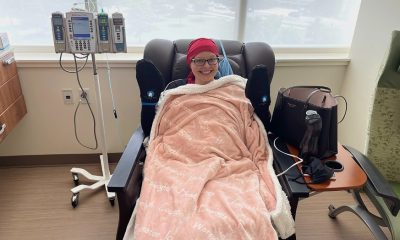 A woman in a hospital chair, wrapped in a blanket, smiling while receiving treatment for cancer. — cancer vaccine hesitancy