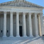 The U.S. Supreme Court building with its iconic columns and steps, under a clear blue sky. — Supreme Court mail voting rule