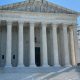 The U.S. Supreme Court building with its iconic columns and steps, under a clear blue sky. — Supreme Court mail voting rule