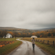 A person walking with an umbrella along a rural road in Bennington County, surrounded by — Bennington VT weather forecast