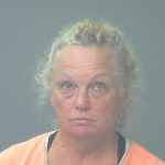 Woman in orange shirt facing camera against gray background — Gulf Breeze animal cruelty arrest