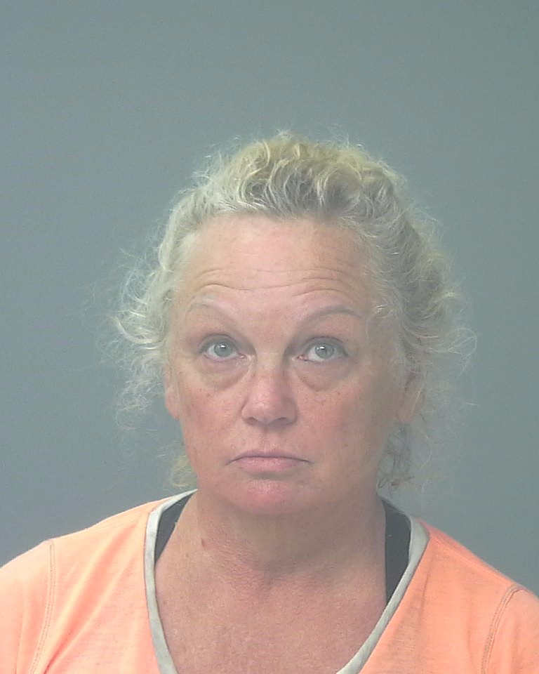 Woman in orange shirt facing camera against gray background — Gulf Breeze animal cruelty arrest