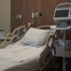 Empty hospital bed in a medical room with monitoring equipment nearby, reflecting hea — Medicaid work requirements lawsuit