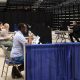 Voters casting their ballots in a spacious indoor polling location, with social d — noncitizen voting supreme court ruling