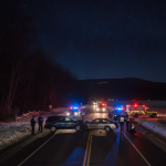 Two vehicles involved in a collision on a snowy road at night, with police and emergency vehicle — Shaftsbury VT car crash