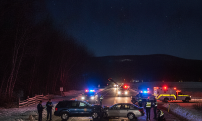 Two vehicles involved in a collision on a snowy road at night, with police and emergency vehicle — Shaftsbury VT car crash