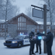 Three police officers in winter gear discussing near a police car — Vermont State Police Shaftsbury barracks investigation