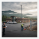 Vermont State Police Shaftsbury Barracks with officers and construction activity in the background under a cloudy sky.