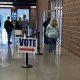 Voters entering a polling place with a 'Vote' sign pointing the way during election season. — ICE at polling places lawsuit