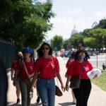 AAPI women walk together along a sunny Washington, D.C., sidewalk, carrying bags and wear — AAPI Women Reproductive Health