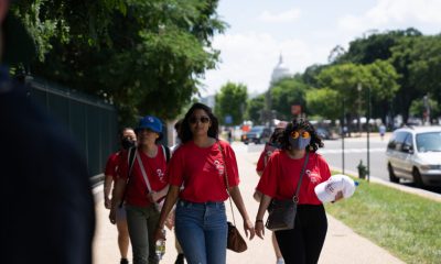 AAPI women walk together along a sunny Washington, D.C., sidewalk, carrying bags and wear — AAPI Women Reproductive Health