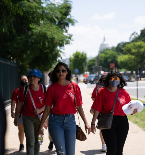 AAPI women walk together along a sunny Washington, D.C., sidewalk, carrying bags and wear — AAPI Women Reproductive Health