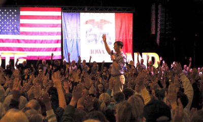 A crowd raises their hands in response to a speaker at a political rally with Am — Democrats majority of governors offices