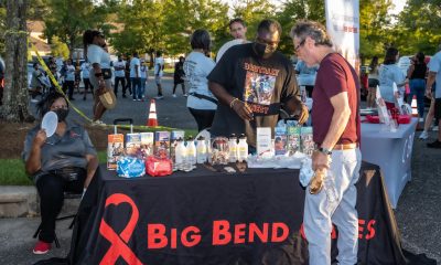 A community event with a table displaying HIV prevention materials and a man interacting w — federal HIV prevention grants