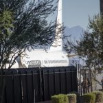 Trump deportation analysis: a white passenger plane behind a tall black fence, with people nearby