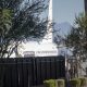 Trump deportation analysis: a white passenger plane behind a tall black fence, with people nearby