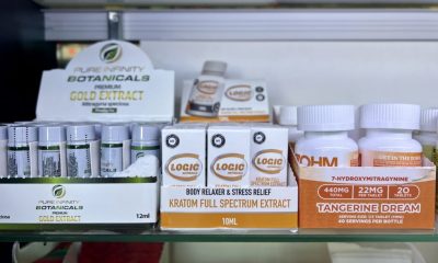 Display of kratom products including extracts and capsules on a store shelf, highlighting kratom and 7-OH laws.