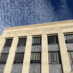 Facade of a county courthouse with a cloudy sky above, symbolizing justice — district attorney elections prison admissions