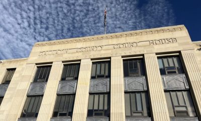 Facade of a county courthouse with a cloudy sky above, symbolizing justice — district attorney elections prison admissions