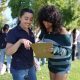 Two young women discussing and taking notes outdoors, surrounded by a group of people in — Gen Z abortion ballot measures