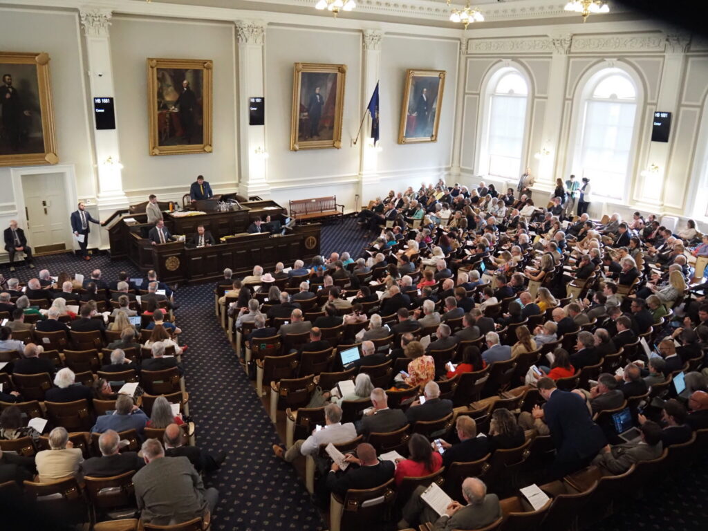 A packed legislative chamber with numerous attendees and officials, highlig — state legislative races competitive chambers