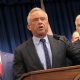 Robert F. Kennedy Jr. speaking at a podium with two men in suits behind him, in a formal — FDA abortion pill safety review
