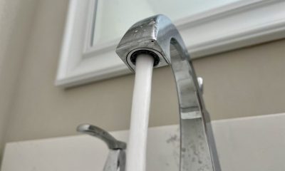 Close-up of a kitchen faucet with water flowing, highlighting rising household water bills.