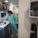 A healthcare worker in teal scrubs prepares supplies in a clinic as the uninsured rate rises. — uninsured rate rising